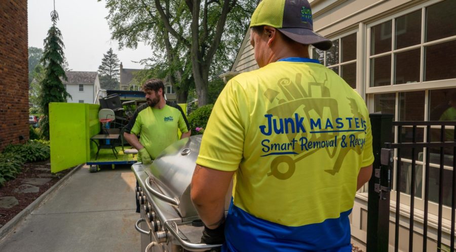 Junk Masters team hauling grill to the truck