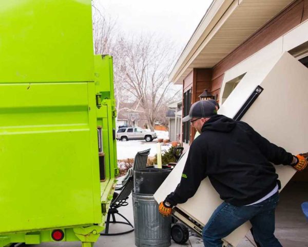 Two professionals performing refrigerator removal services in Minnesota