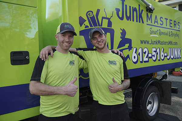 Junk Masters crew smiling next to the truck during junk removal in Columbia Heights