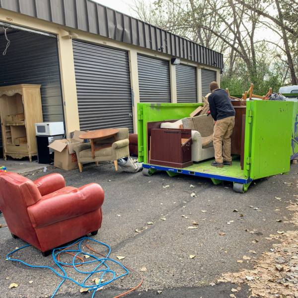 Junk removal professionals loading furniture onto the truck while cleaning out a storage unit in Maplewood